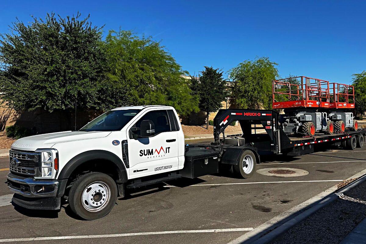 Summit Rentals truck and gooseneck trailer delivering two Skyjack scissor lifts across the Phoenix metro service area