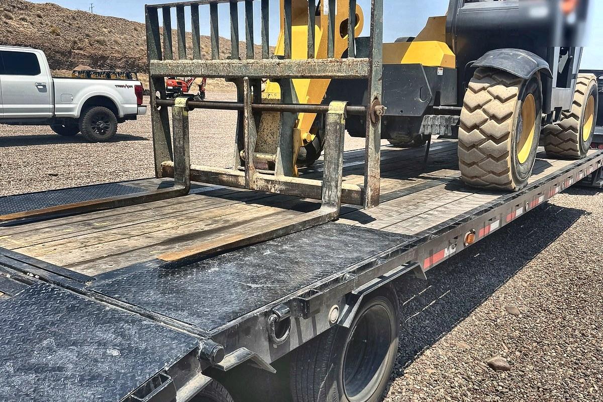 A Gehl RS6-34 telehandler being loaded onto a flatbed trailer at the Summit Rentals yard